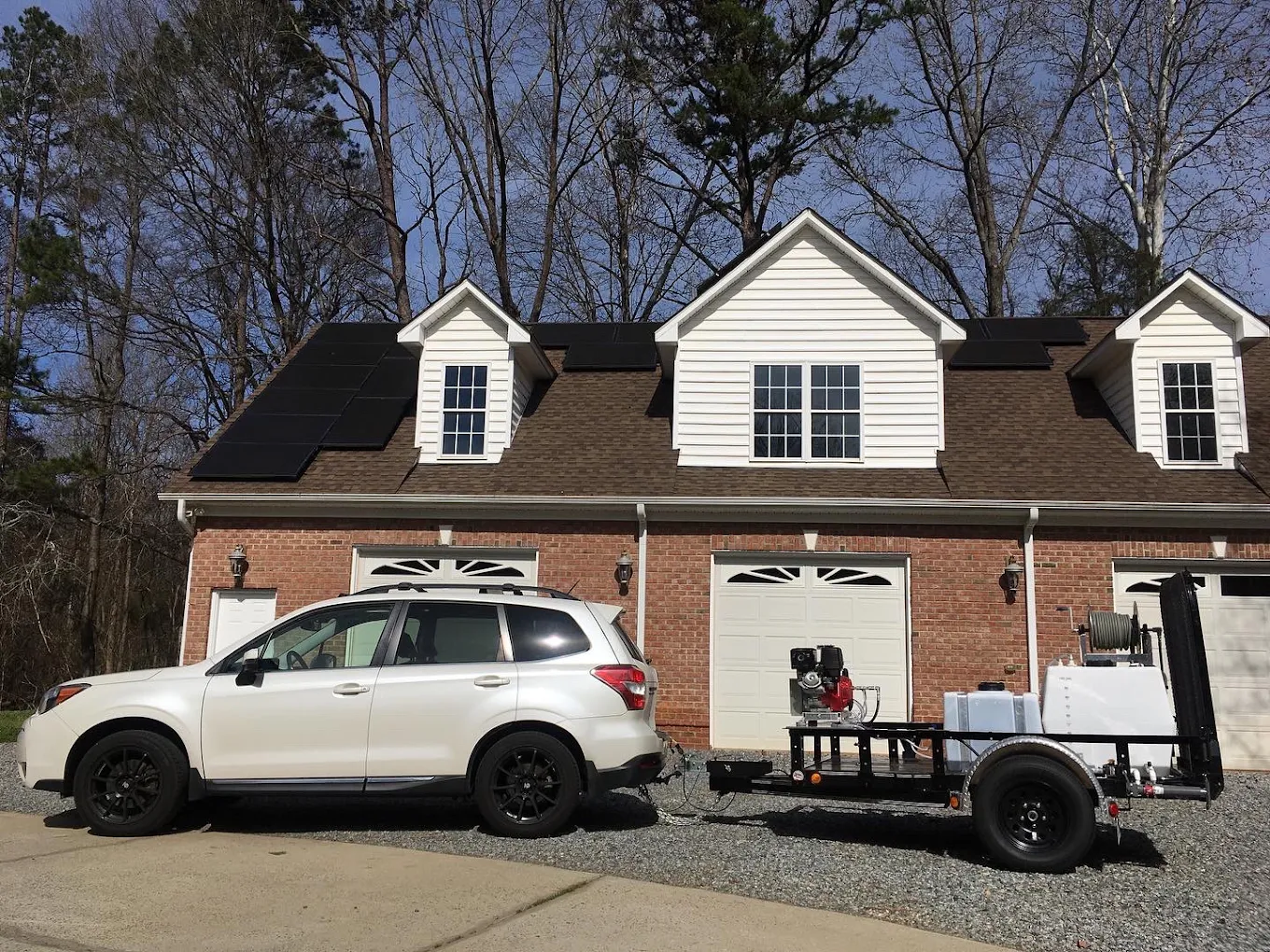 Critical Clean pressure washing equipment staged at a brick home